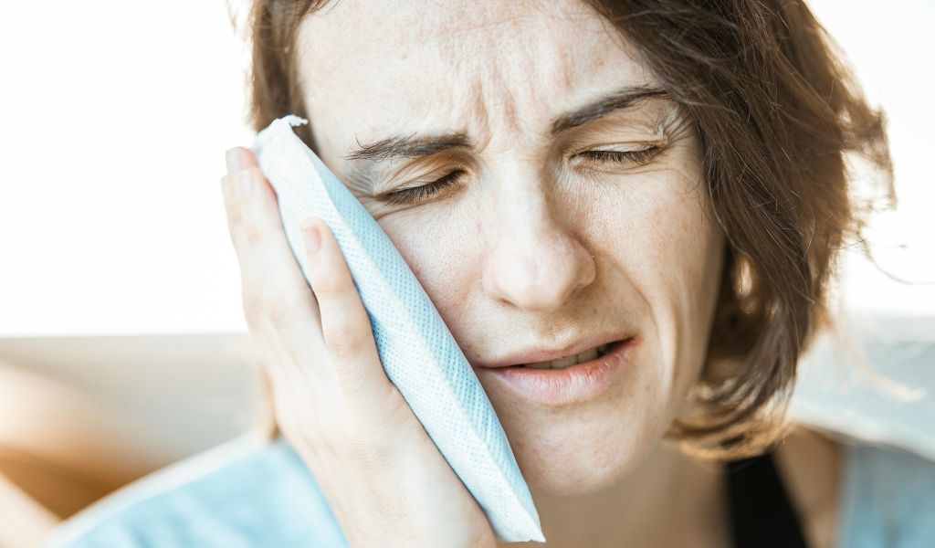 Chườm ấm hoặc lạnh vùng sưng để giúp giảm sưng, giảm đau vùng má