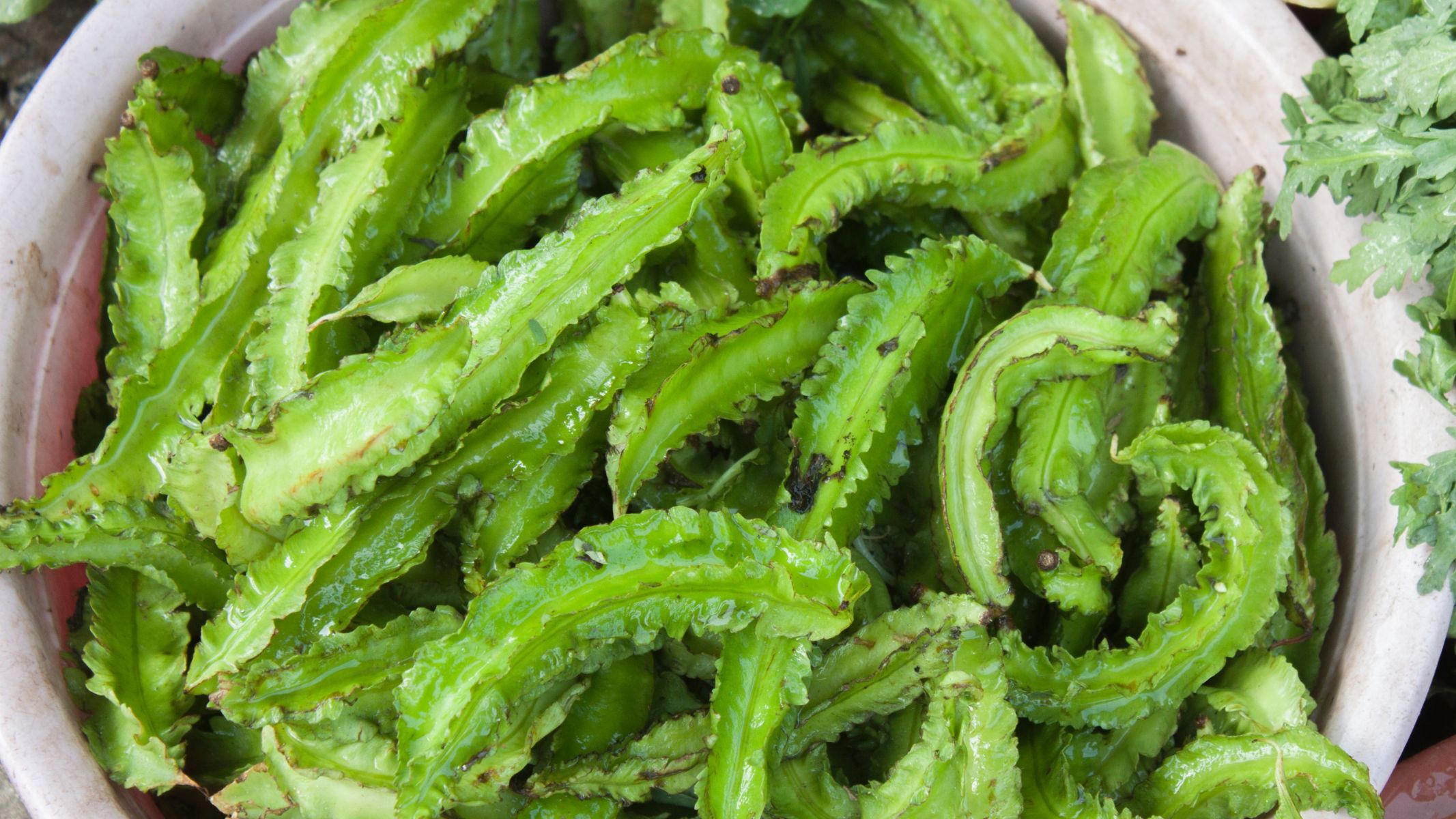 Nên rửa sạch đậu rồng và ngâm với nước muối loãng trước khi ăn sống