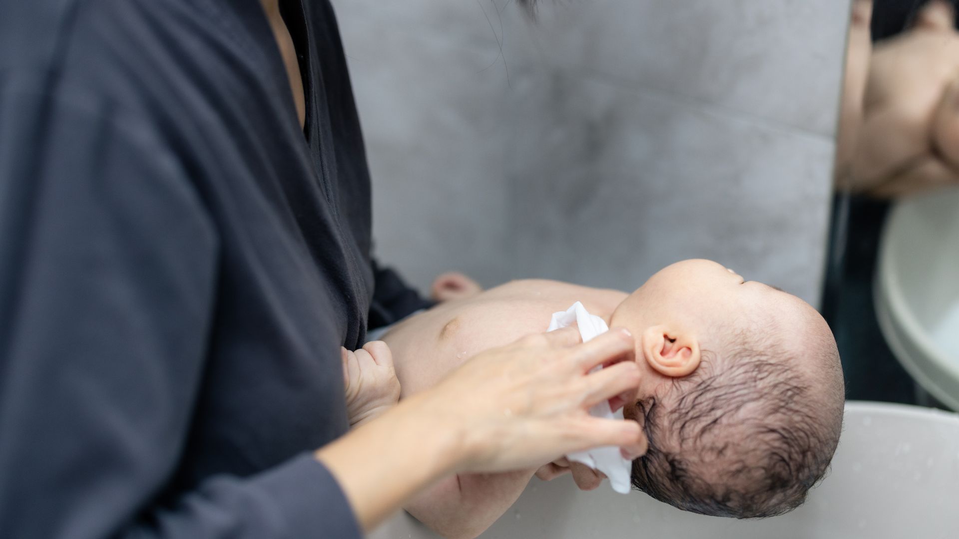 Mẹ cần gội đầu nhẹ nhàng cho bé bằng nước ấm để thóp luôn khoẻ mạnh