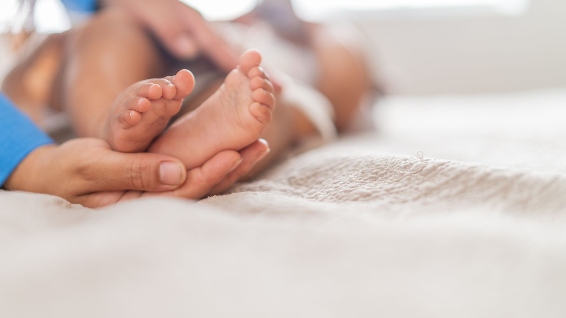Cha mẹ hãy vỗ nhẹ vào lòng bàn tay hoặc chân của bé để đánh thức bé
