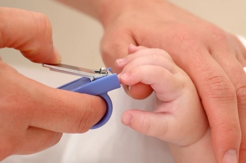 Bấm cắt tỉa móng tay trẻ để tránh cho trẻ cào xước mặt