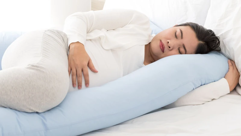 Ngủ nghiêng sang trái và dùng gối ôm giúp giảm đau lưng hiệu quả