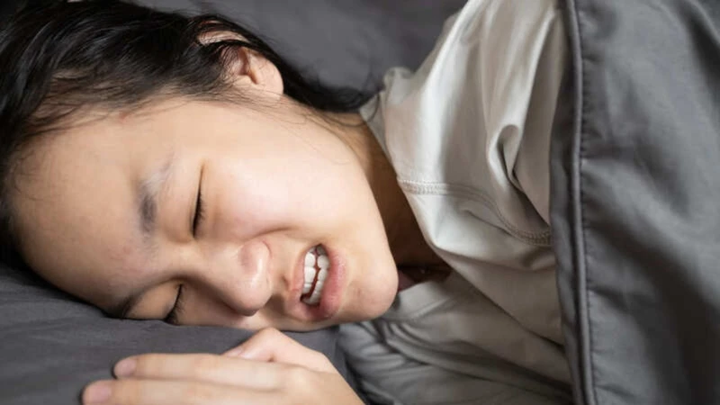 Nghiến răng khi ngủ cũng có thể là nguyên nhân khiến răng bị lung lay