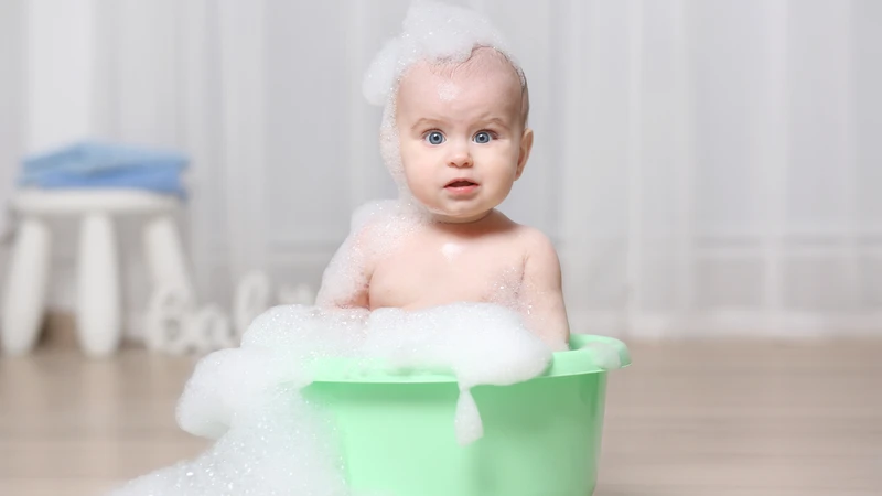 Tắm nước ấm trong thời gian ngắn giúp hạn chế kích ứng làn da của bé