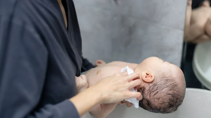 Mẹ cần gội đầu nhẹ nhàng cho bé bằng nước ấm để thóp luôn khoẻ mạnh